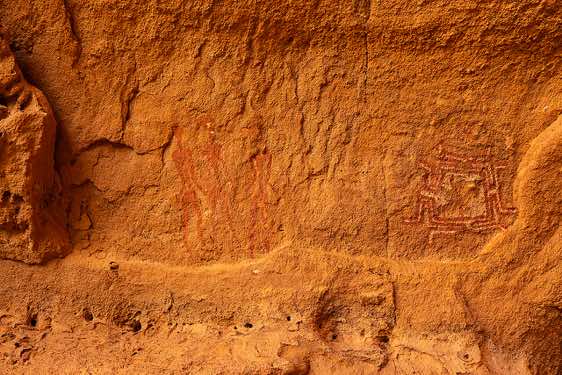 Rock painting of three human figures and a geometric design with red and white lines, Gaora Hallagana, Ennedi, northeastern Chad
