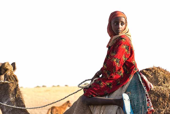 Nomad girl on a camel at a well