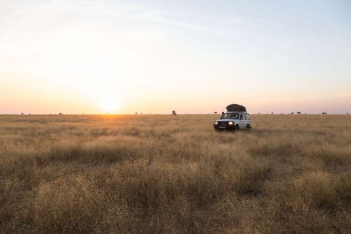 Off-road vehicle approaching at sunset