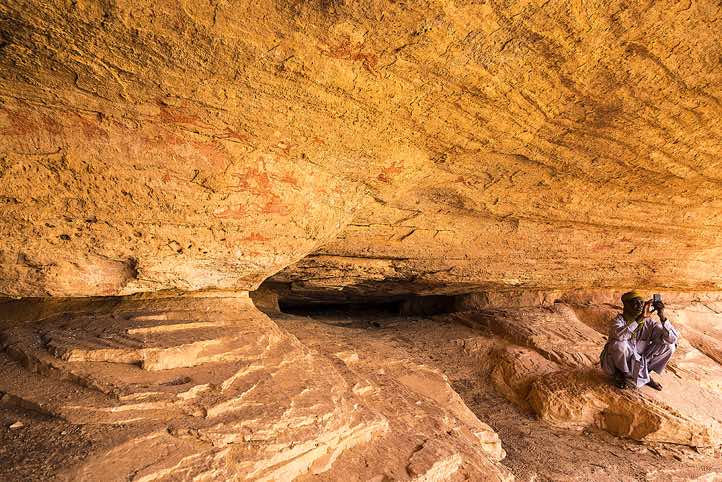 Local guide Haraoun with mobile phone at Terkei Cave, Ennedi, northeastern Chad