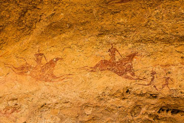Rock painting of galloping horses and riders behind two running figures, Terkei Cave, Ennedi Mountains, northeastern Chad
