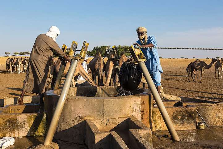 Nomads draw water from a well to water their herds