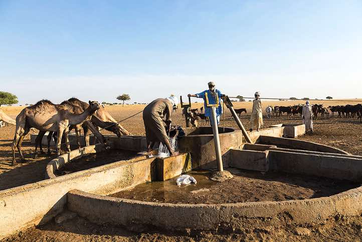 Nomads draw water from a well to water their herds