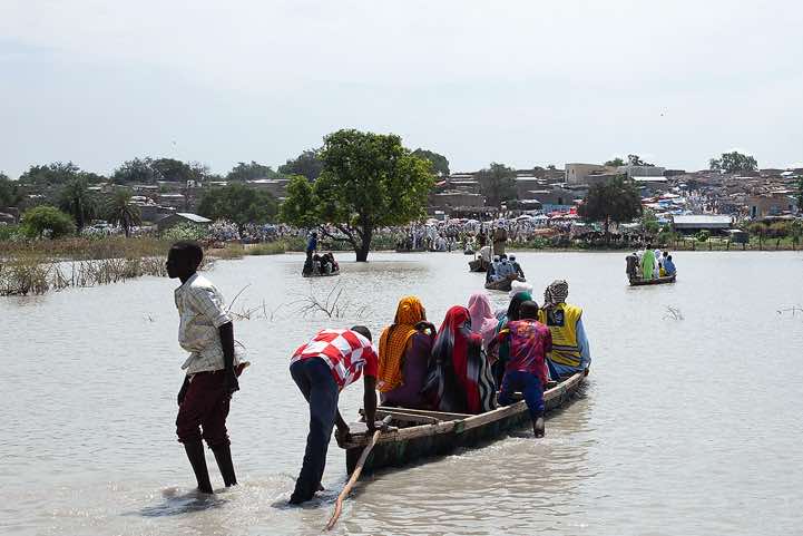 Wooden canoes are used to reach a village and it's marketplace on the opposite side of a lake