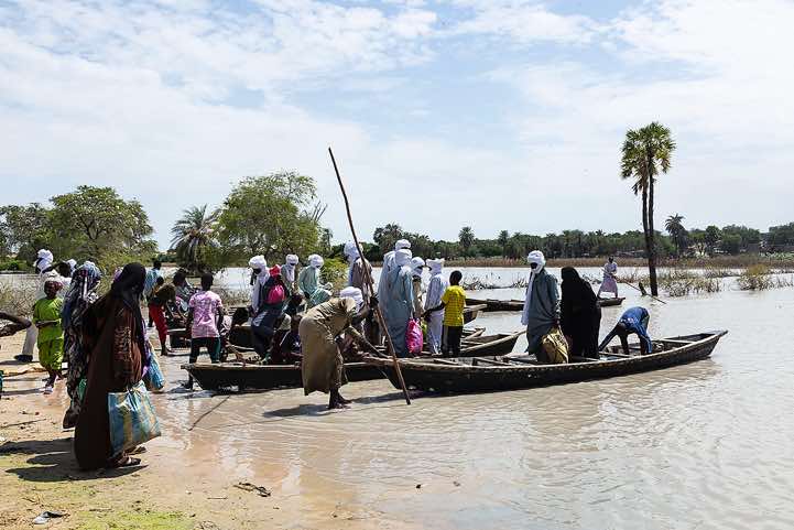 Wooden canoes are used to reach a village and it's marketplace on the opposite side of a lake