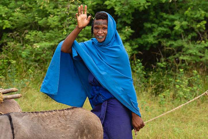 After the Gerewol festival a Wodaabe (Bororo) woman waves goodbye as she's on the move again