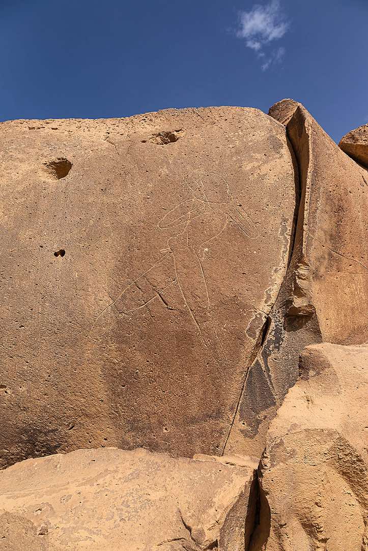 The famous 'Man of Gonoa' engraving, near Bardaï, depicting a larger than life-size masked but otherwise naked male figure holding a club or some other object, Tibesti region