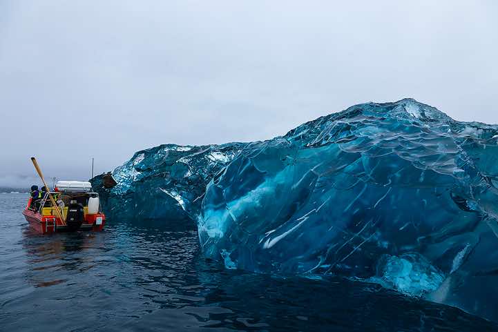 Boat approaching a huge block of ice, Sermilik Fjord
