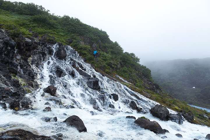 Waterfall on the outer slope of Koshelev Volcano, Pauzhetka area. The water in the local rivers and waterfalls has a distinct white colour due to the concentrated alumina