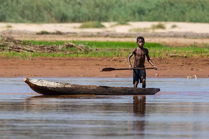 Young boy with his wooden canoe on the Tsiribihina River, Western Madagascar