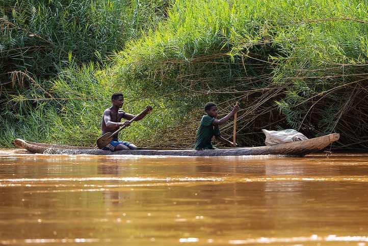 Men in a wooden canoe on the Tsiribihina River, Western Madagascar