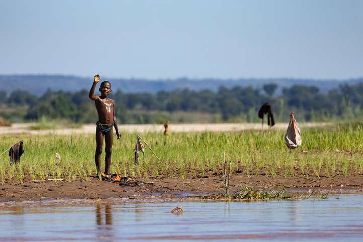 Young boy waving, Tsiribihina River, Western Madagascar