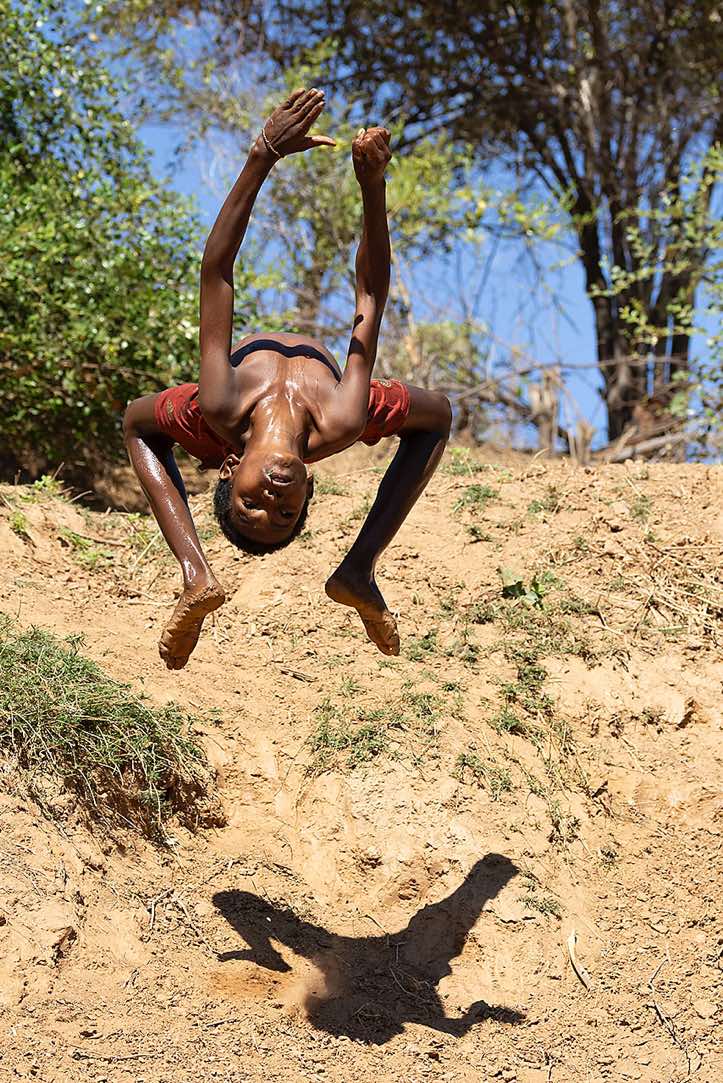 Young boy showing off his acrobatic skills, Tsiribihina River, Western Madagascar