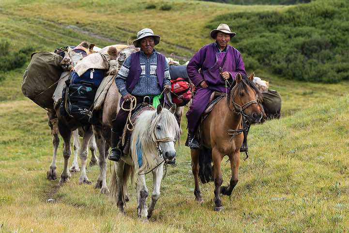 Camel herders Aagii and Bold approaching on horses, Tavan Bogd National Park, Altai Mountains, Western Mongolia