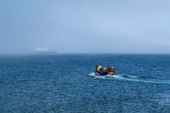 Zodiac heading into the fog towards 'Plancius" from the landing site at Torellneset