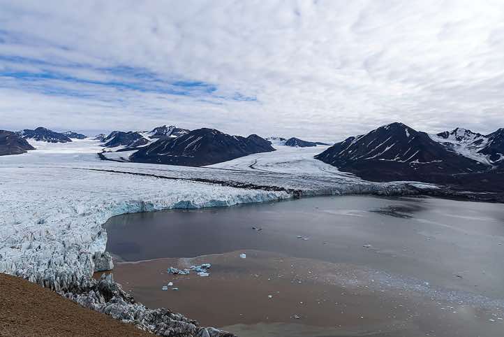 The merging glaciers Osbornebreen and Vintervegen flow into St. Jonsfjorden, Valentinryggen mountain ridge, Oscar II Land