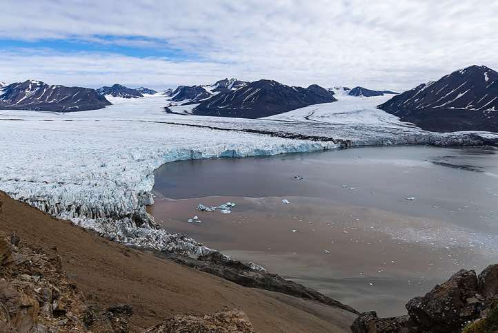 The merging glaciers Osbornebreen and Vintervegen flow into St. Jonsfjorden, Valentinryggen mountain ridge, Oscar II Land